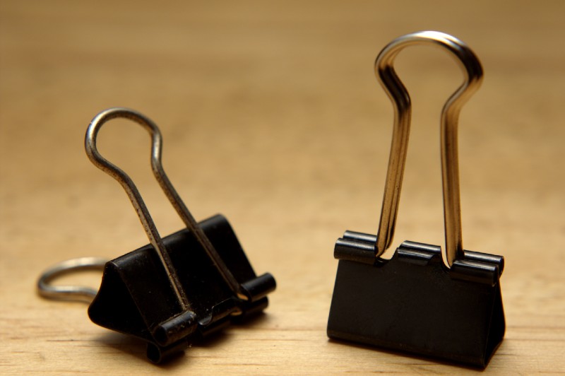 closeup of bulldog clips on wooden background-binder clips