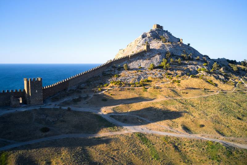 An ancient defensive wall that runs along the crest of a mountain on the seashore-terrain