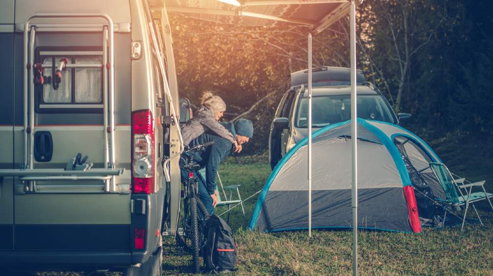 Camping Family Time. Father Playing with His Daughter Around Camper Van RV and Tents | RVing and Prepping - Something to Think About | featured