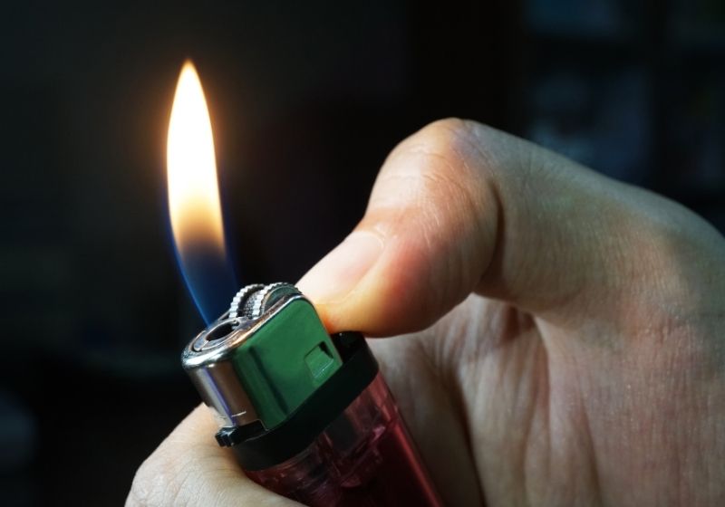 Hand holding burning gas lighters Must have survival items SS