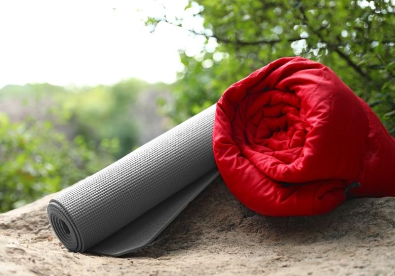 Rolled sleeping bag and mat on rock Camping in the rain SS