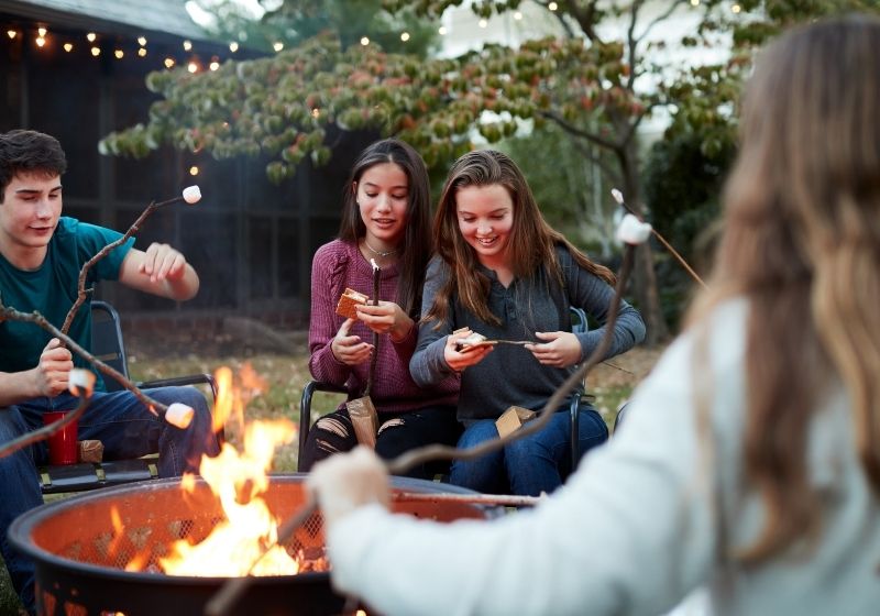Teenage friends making samores | How to Book a Campsite from Parks to RVs to Backyards