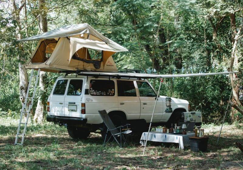 Tent on roof of suv car parked in woods Car camping essentials PX