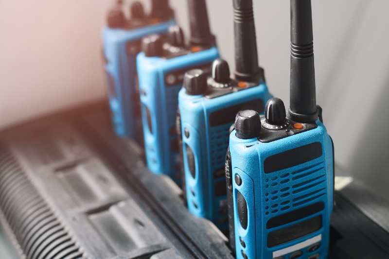 A set of blue walkie-talkies stand in a row-Emergency Radios