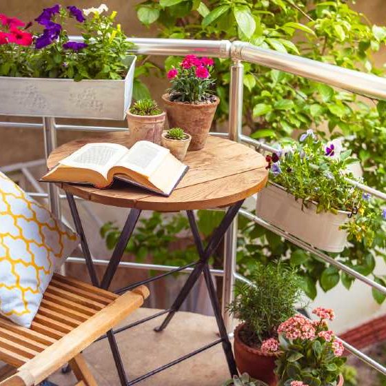 Beautiful terrace or balcony with small table, chair and flowers | 8 Cheap Options to Create a Small Space Garden | featured