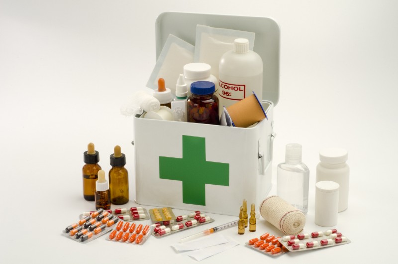 Open first aid kit filled with medical supplies in white background preparation items