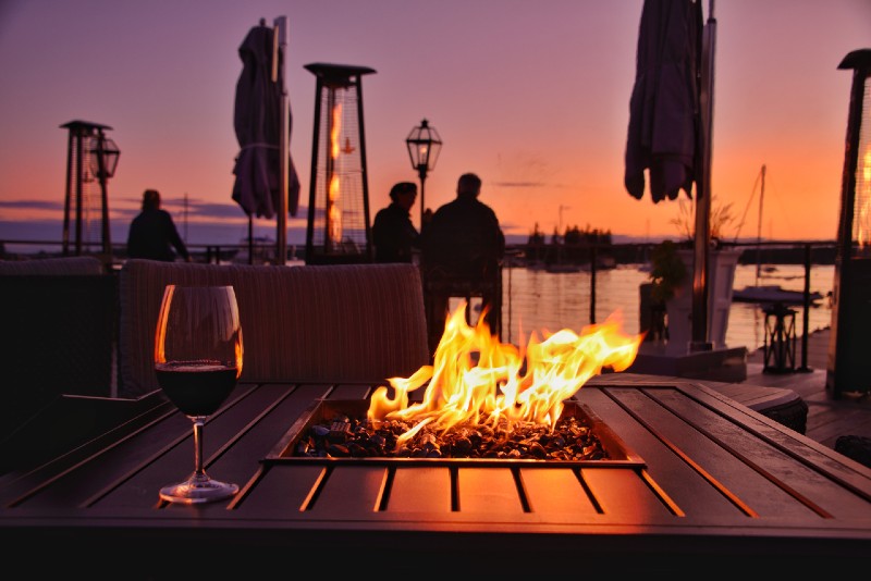 a beautiful sunset scene on a dock with a fire pit fire pit