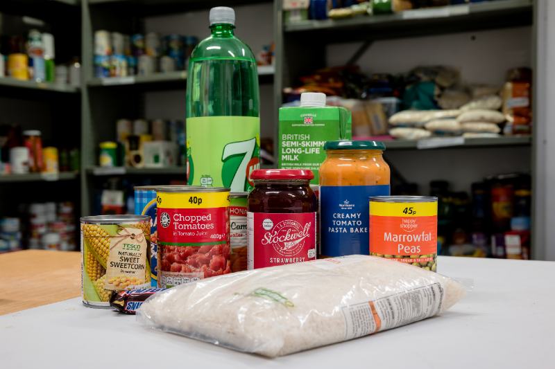 A selection of donated food and drink in a Trussell Trust local church food bank ready for food parcels-Survival Food Kit