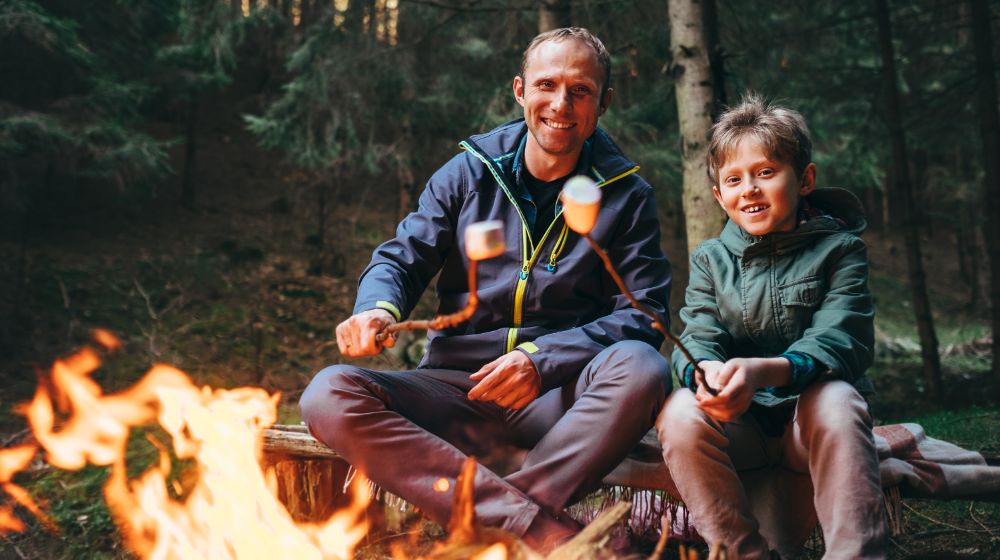 Father son roast marshmallows | REI Camping | Featured