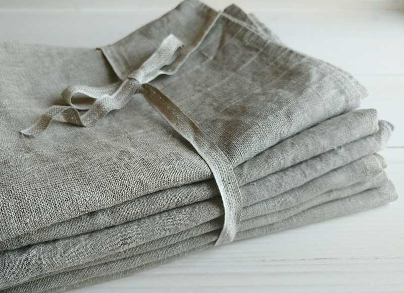 Pile of natural linen towels, napkins on white wooden background-what to bring to picnic