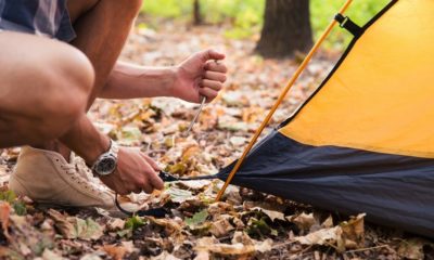 Portrait of a man setting up a tent on a camping trip | How to Find the Best Places to SET UP YOUR TENT | Featured