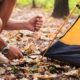 Portrait of a man setting up a tent on a camping trip | How to Find the Best Places to SET UP YOUR TENT | Featured