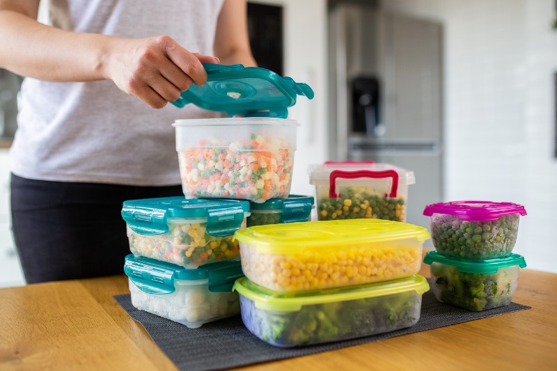 Woman Preparing Containers Of Mixed Frozen Vegetables For Refrigerator Survival Food Kit