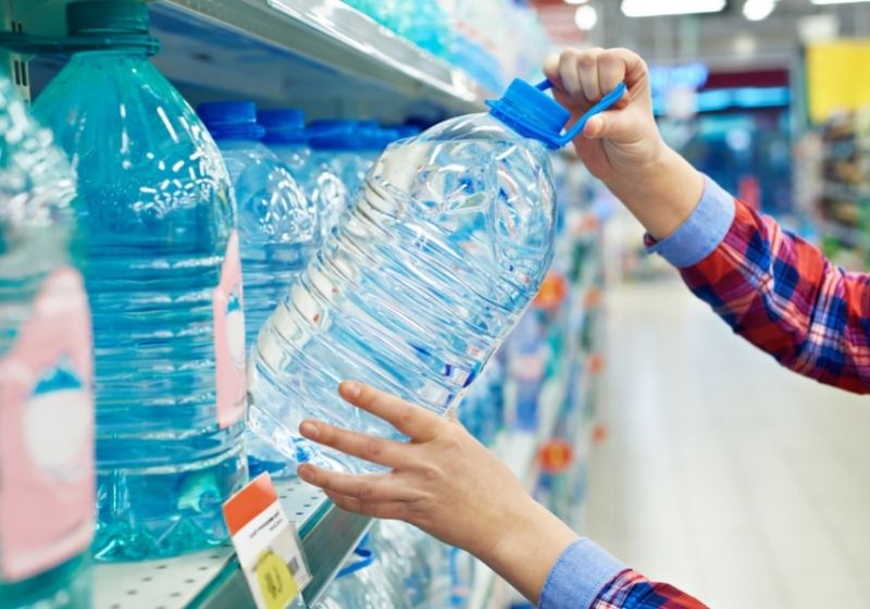 Woman with bottle drinking water in shop | Hurricane Preparedness List (EASY MONETIZATION)