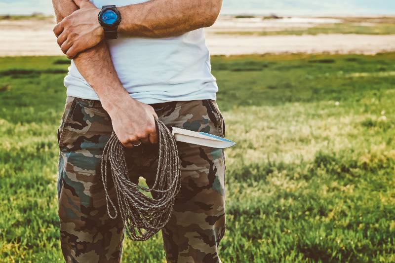 Adventure wilderness nature man with knife and rope in camouflage pants-Must Look for in a Survival Knife