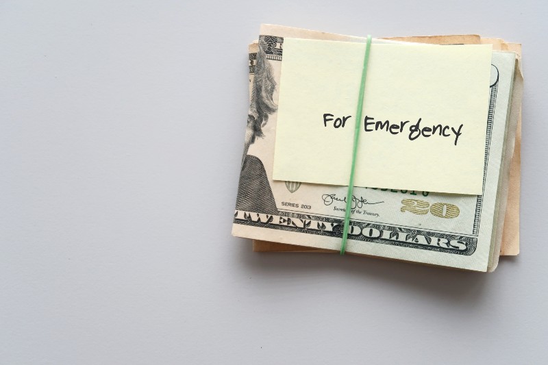 Dollars cash money and paper note with text written FOR EMERGENCY-Survival Economic Collapse
