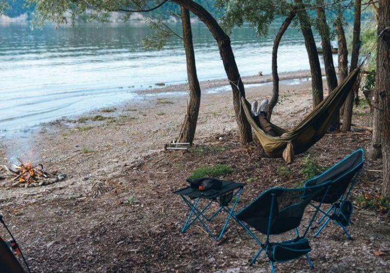 Klappstühle und ein Tisch stehen am Ufer des Flusses|  Picknicktisch-Set |  Top Picknicktisch-Kits auf Amazon 2021