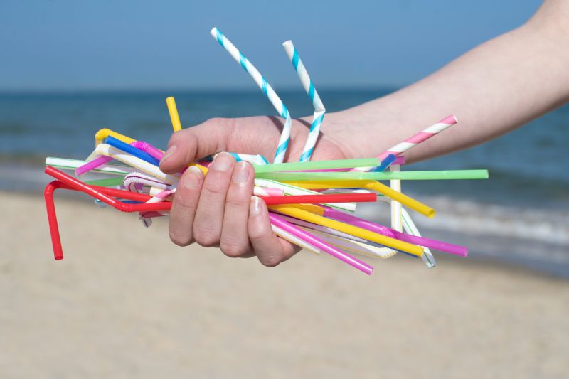 Hand holding plastic straws | REI camping