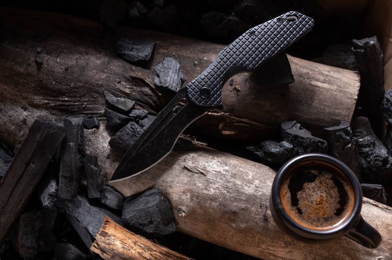 Couteau et café.  Couteau de poche pliable et café infusé - un incontournable dans un couteau de survie