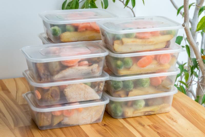 Stack of home cooked roast chicken dinners in containers ready to be frozen for later use-Camping Safety Tips