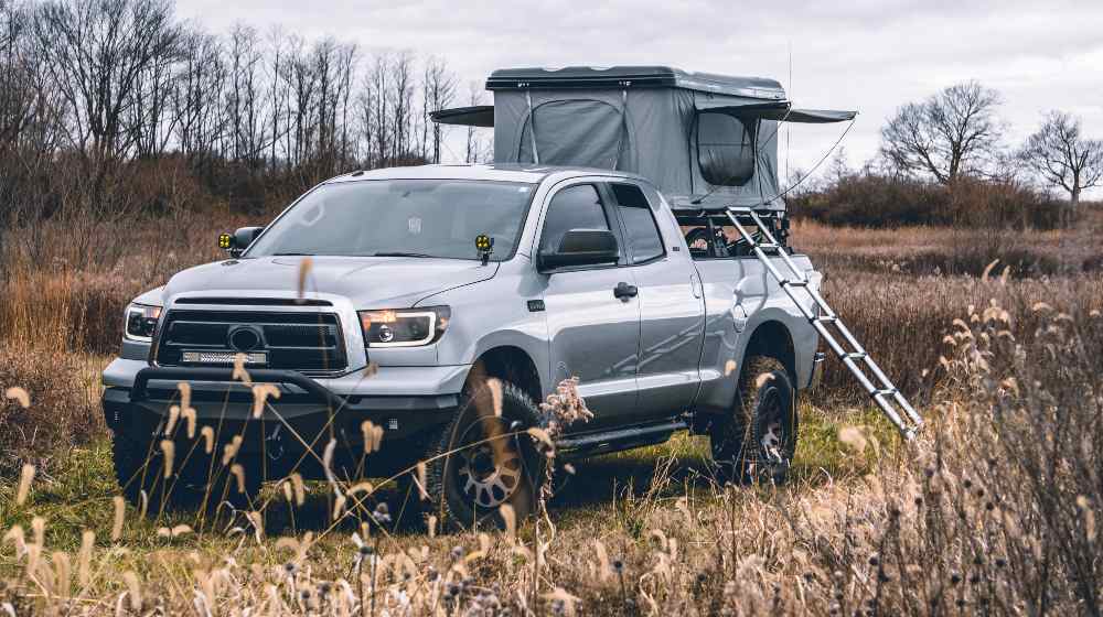 Truck with Roof Top Tent in FieldTruck Bed Camping | Everything You Need to Know about It | featured