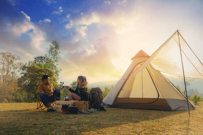 Young couples have good time morning on camping trip with sunrise background-camping holiday