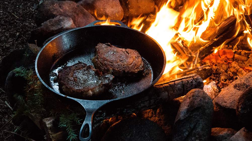 A Frying Pan with Two Slices of Steak on Campfire | Camping Food Hacks | Featured