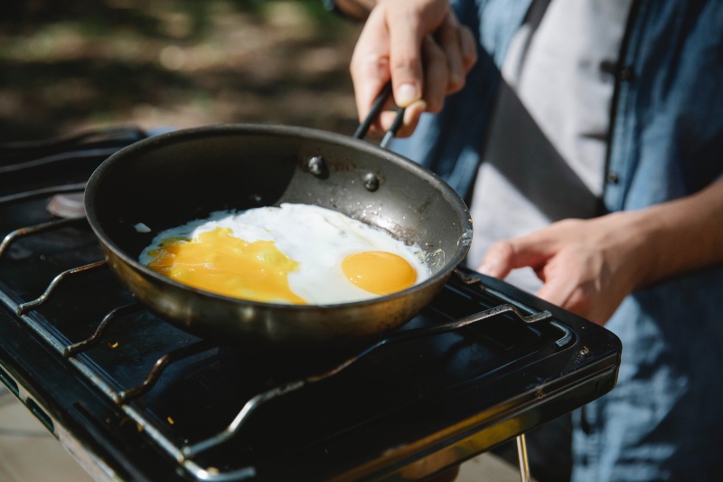 Man Frying Eggs on Skillet | Camping Food Hacks