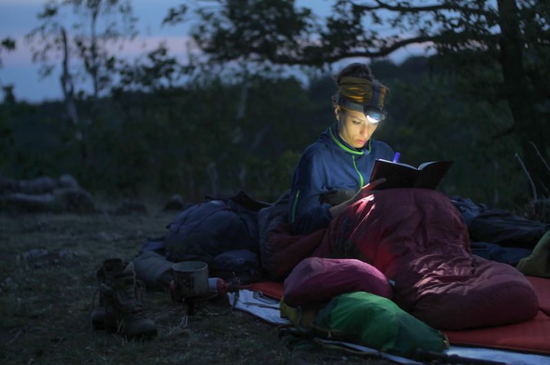 Caucasian female hiker reading | Headlamps