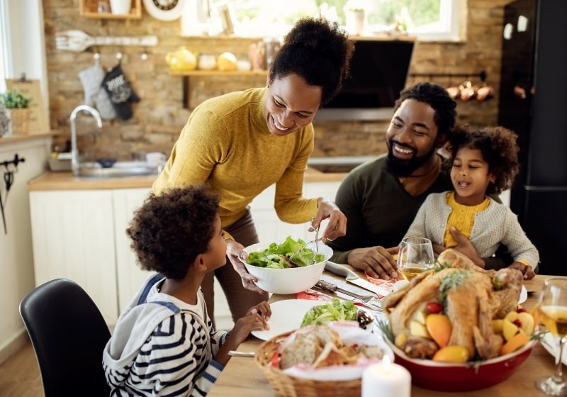 Happy African American woman having Thanksgiving | Thanksgiving Survival Guide | 11 Tips for a Healthier Holiday