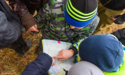 The children went camping. Teenagers study a map of the area. Learning to survive in difficult conditions | Have You Prepared Your Kids for Surviving? | featured