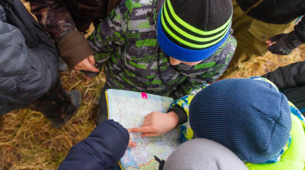 The children went camping. Teenagers study a map of the area. Learning to survive in difficult conditions | Have You Prepared Your Kids for Surviving? | featured