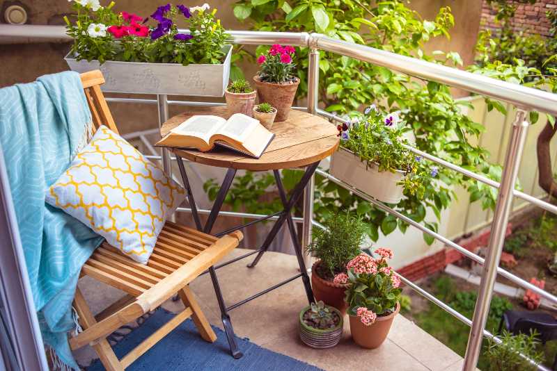 Beautiful terrace or balcony with small table, chair and flowers-Balcony Gardens Ideas