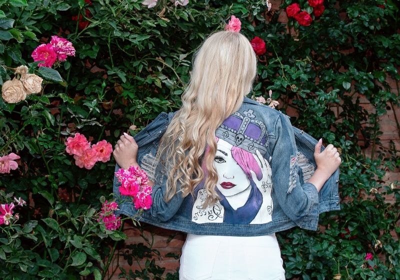 Blonde girl posing in a painted Jean jacket | upcycled clothing