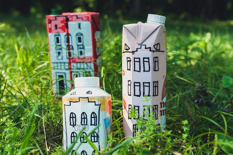 Houses and toy cars made from milk bags on grass-Upcycling Ideas