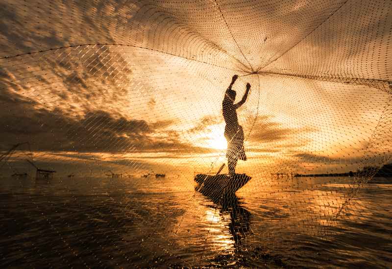 Silhouette Fisherman Fishing Nets on the boat-primitive fishing techniques