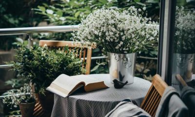 Small table, book and flowers on a beautiful terrace or balcony | 7 Charming Balcony Gardens Ideas | featured