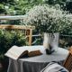 Small table, book and flowers on a beautiful terrace or balcony | 7 Charming Balcony Gardens Ideas | featured