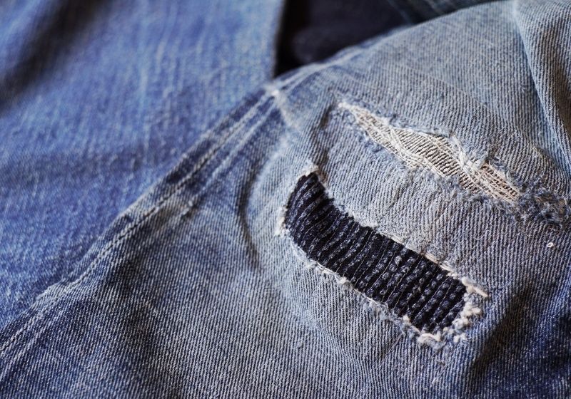 Stitching on torn denim blue jeans patched | upcycled clothing 