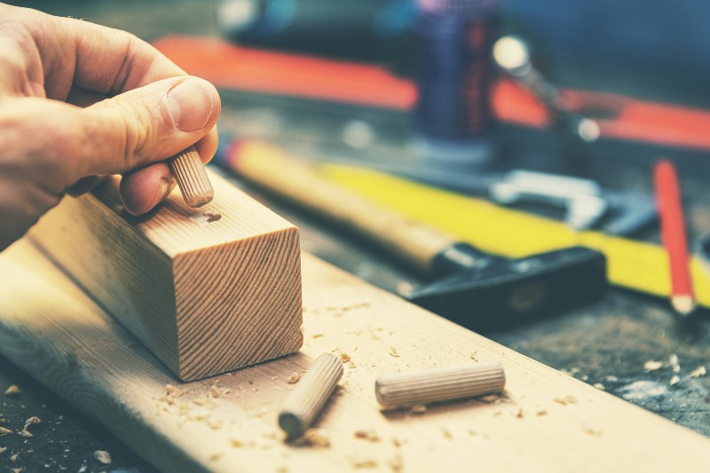 joiner putting dowel pin into a piece of wood | Joining Wood with Dowels