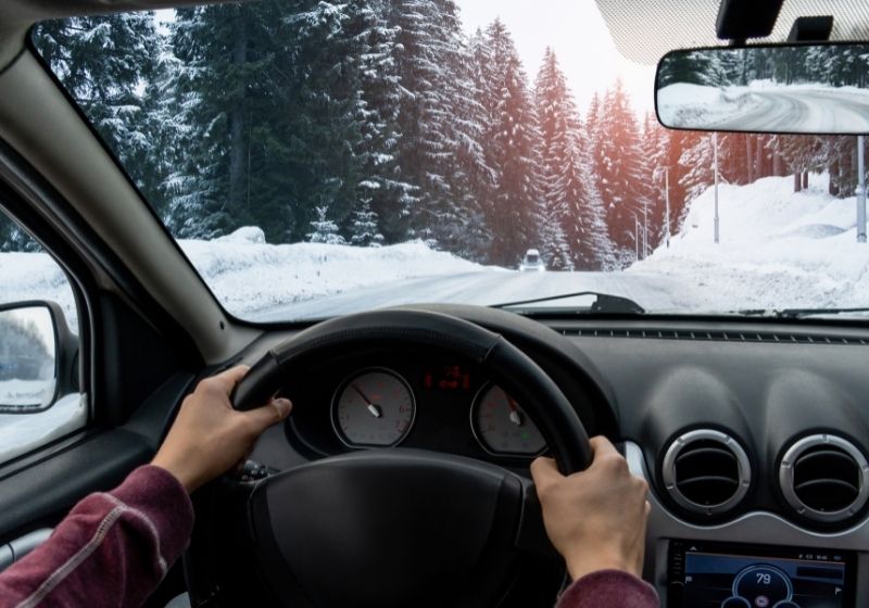 A man drives a car on a winter road | Winterize Car | 13 Ways on How to Winterize a Car
