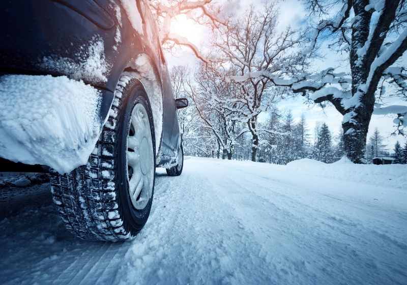 Car tires on winter road covered with snow | Winterize Car | 13 Ways on How to Winterize a Car