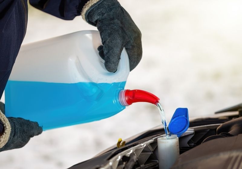Man with gloves pouring antifreeze coolant | Winterize Car | 13 Ways on How to Winterize a Car