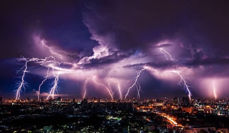 Lightning storm over city in purple light | How to Survive a Thunderstorm Survival Strategy | Survival Strategies