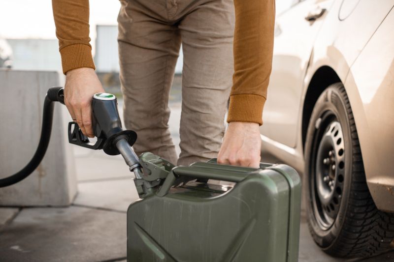 El hombre llena el tanque de combustible con gasolina  ¿Qué debo reunir para el colapso económico?