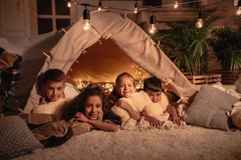 Multiethnic group children resting handmade tent | Alternative heat sources for power outages