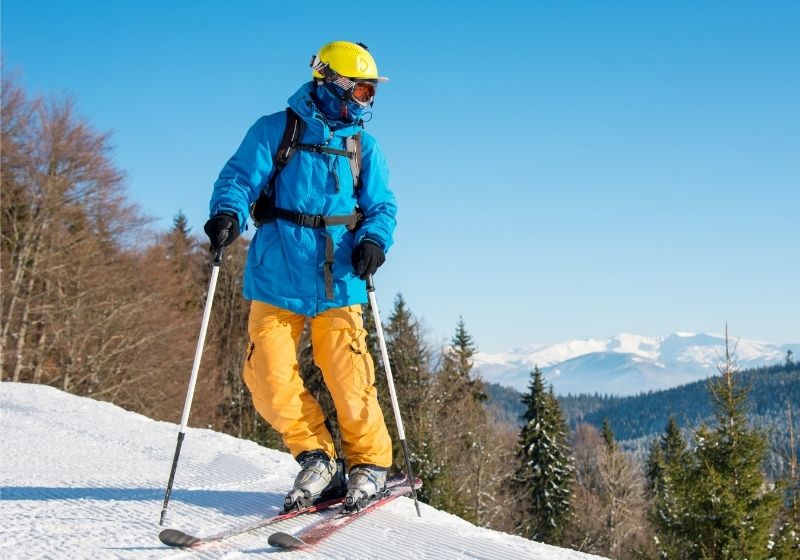 Shot of a professional skier in colorful gear skiing | Avalanche Gear Checklist for Your Avalanche Survival Kit