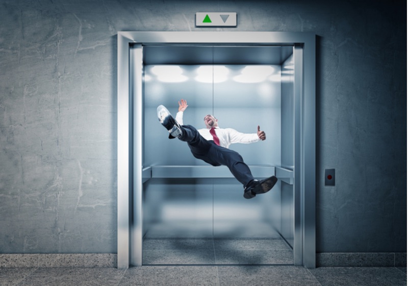 businessman falling in modern elevator | survival strategies | How to Survive a Falling Elevator