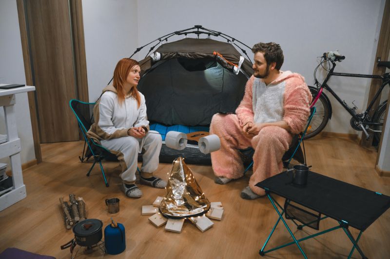 couple-sitting-folding-chairs-by-tent How to Keep Warm Without Electricity 
