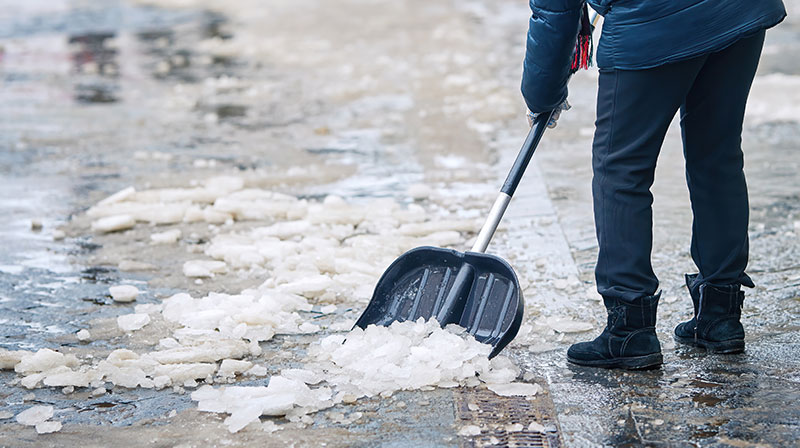Female worker with snow shovel cleans sidewalk in winter season | Homemade Ice Melt | The Easy Way to Melt Ice You Never Knew About (It’s Not Salt!)